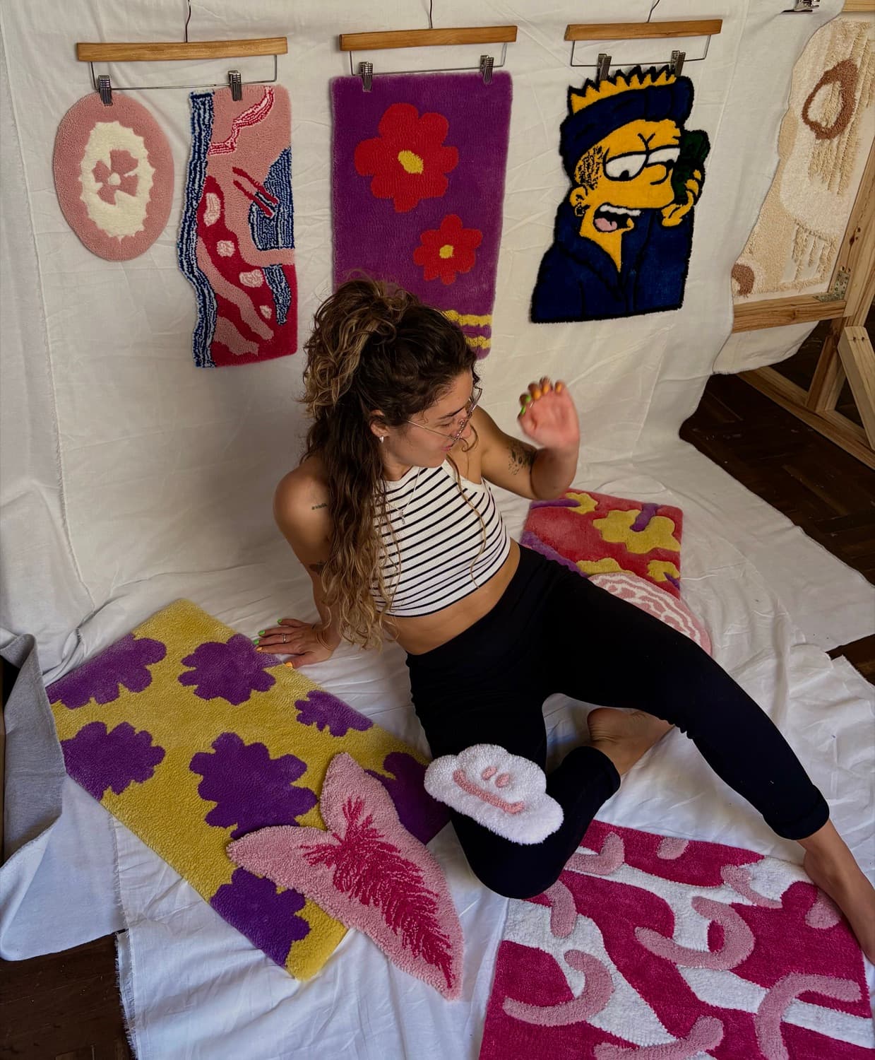 La diseñadora de Templo en el taller, rodeada de sus alfombras